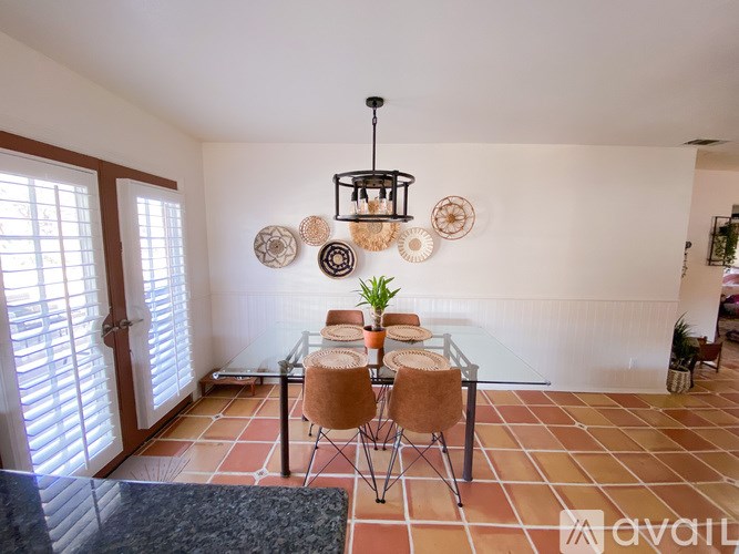 A dining room with a glass table and chairs.