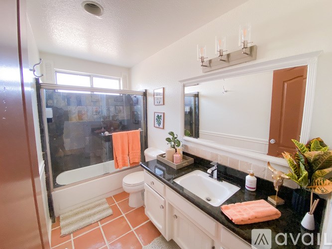 A bathroom with a sink, toilet, and shower.