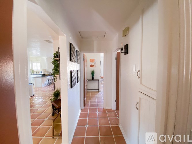 A long hallway with a tiled floor and white walls.
