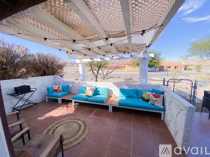 A patio with a white couch and a table with a TV on it.