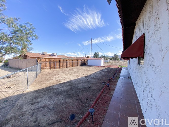 A white building with a red awning sits next to a white wall.