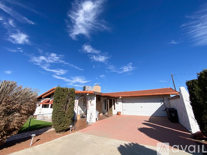 A house with a driveway and a clear blue sky above.