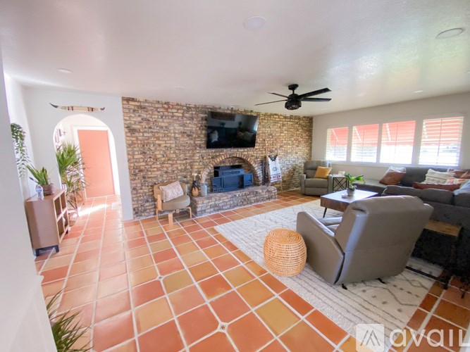 A living room with a brick wall and a fireplace.
