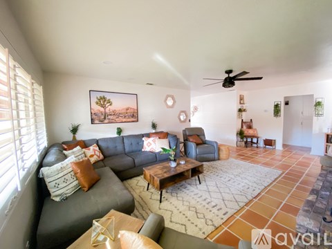 A living room with a grey couch, a brown coffee table, and a painting on the wall.