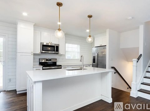 A modern kitchen with a white island and stainless steel appliances.