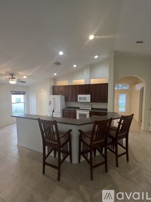 A kitchen with a bar and chairs.