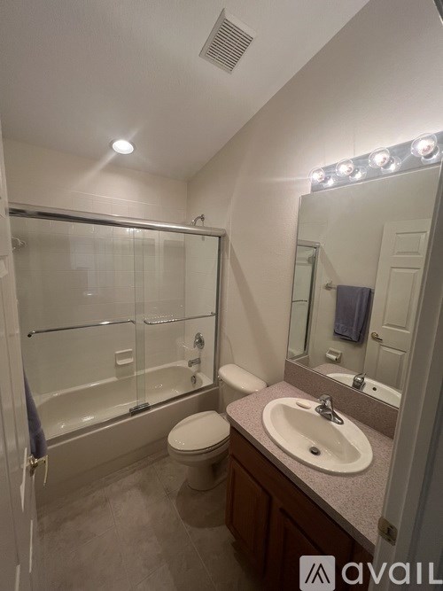 A bathroom with a toilet, sink, and shower.