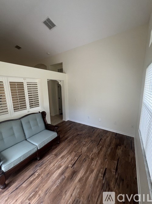 A room with a couch and wooden floors.