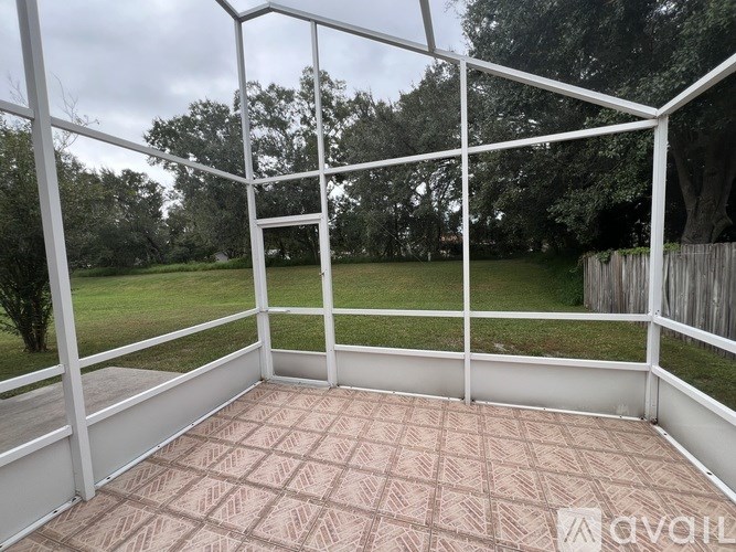 A white enclosed porch with a tiled floor.