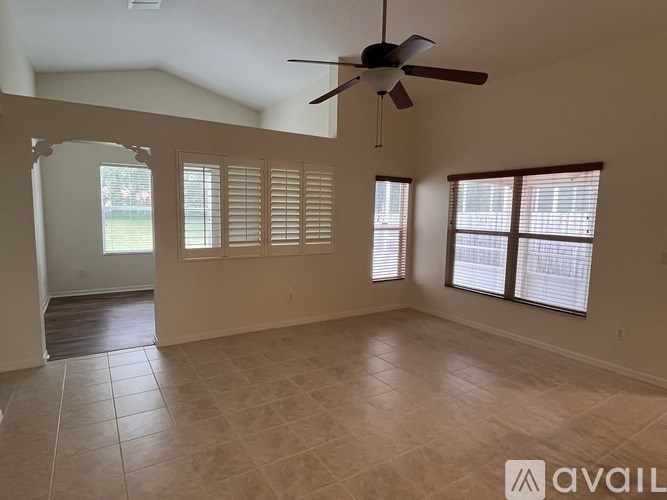A room with a ceiling fan and tiled flooring.