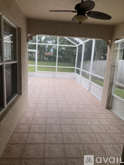 A patio with a ceiling fan and sliding glass doors.