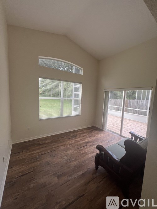 A living room with a couch and a window overlooking a fence.