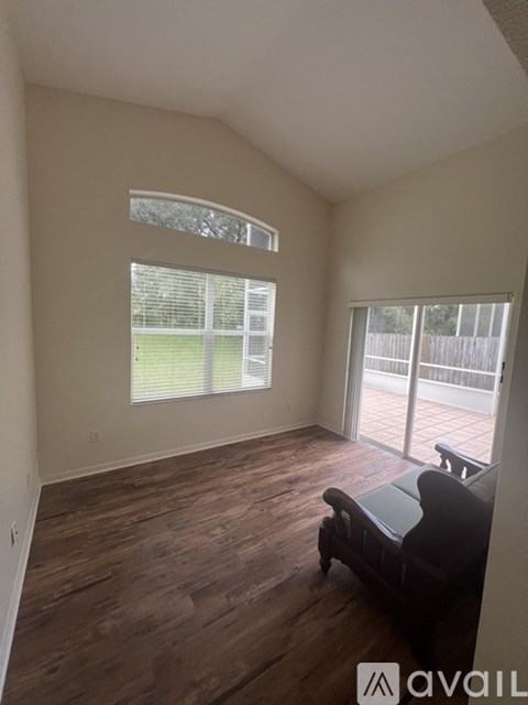 A living room with a couch and a window overlooking a fence.