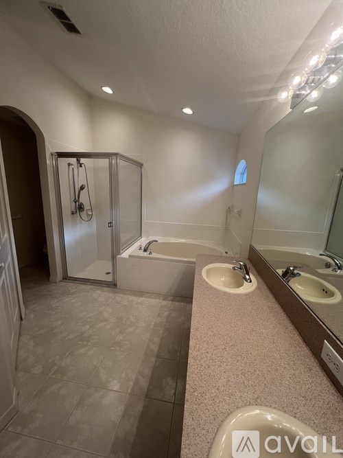 A bathroom with a sink, mirror, and bathtub.