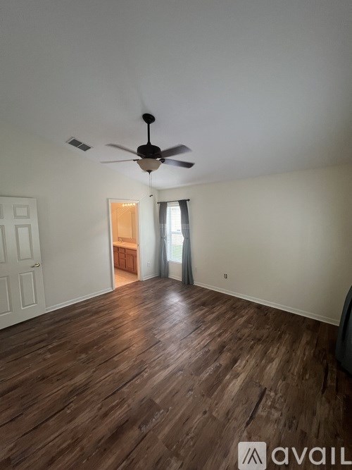A room with wooden flooring and a ceiling fan.