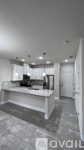 A kitchen with a countertop and a refrigerator.