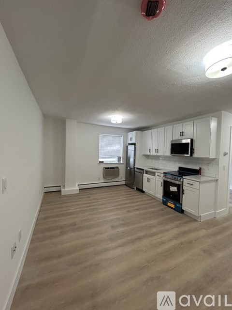 A kitchen with white cabinets and a microwave above the stove.