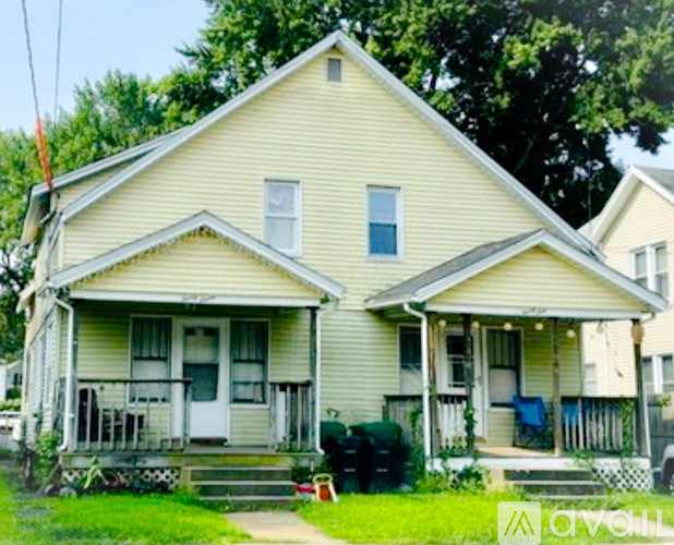 A two-story house with a front porch and a small front yard.