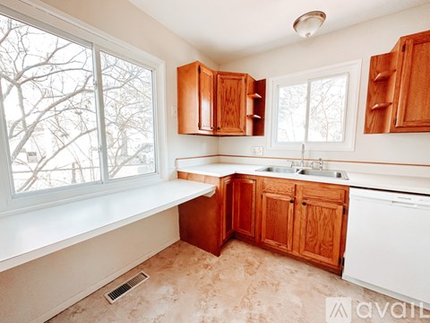 A kitchen with wooden cabinets and a white dishwasher.