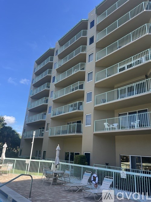 A tall apartment building with a pool in front.