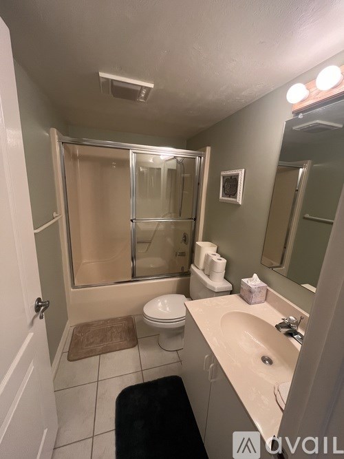 A bathroom with a toilet, sink, and shower.