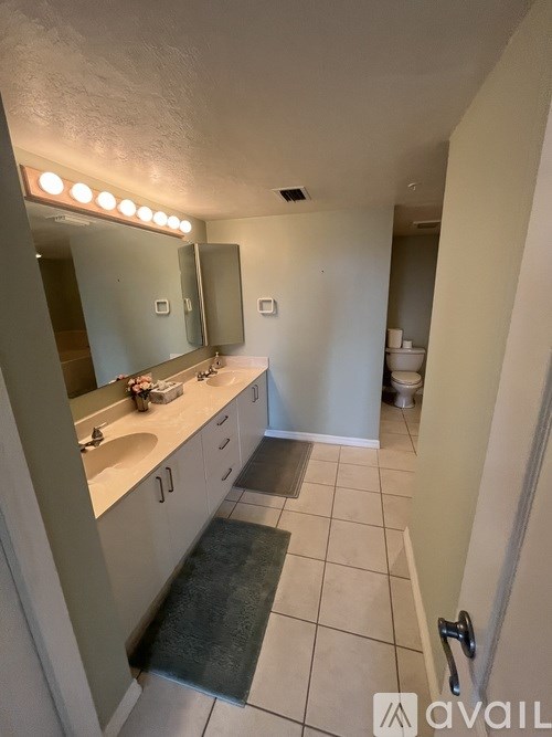 A bathroom with a sink, mirror, and toilet.