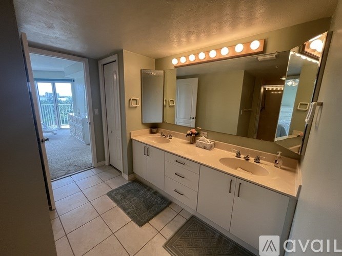A bathroom with a vanity, sink, mirror, and lights.