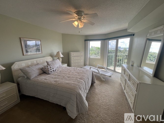 A bedroom with a large bed and a ceiling fan.