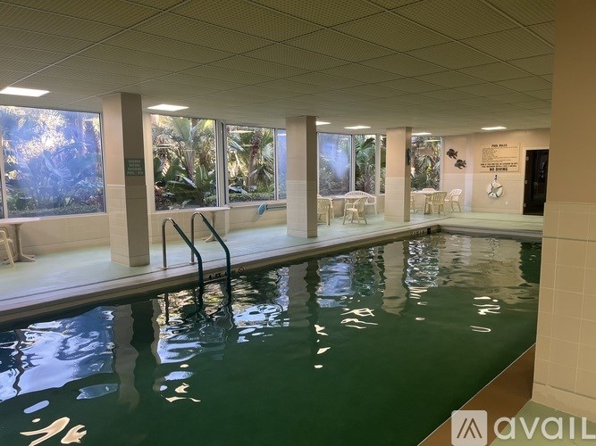 A large indoor swimming pool with a glass wall on one side.