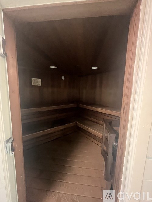 A room with wooden floors and a door on the left side.
