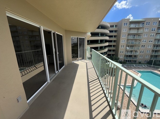 A balcony with a pool in the background.