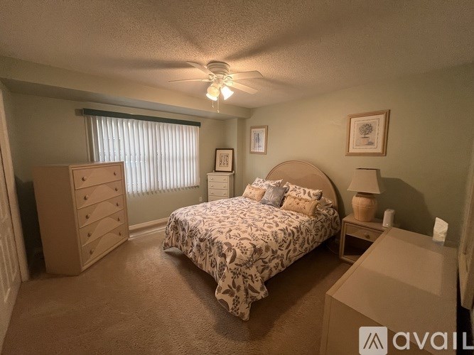 A bedroom with a bed, dresser, and window with blinds.