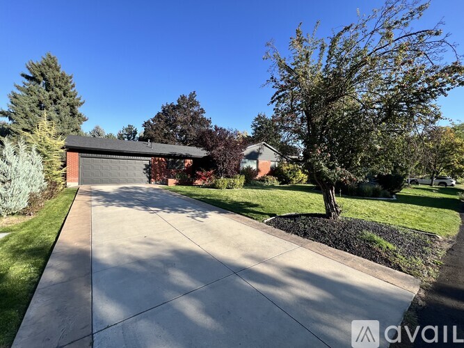 A house with a driveway and trees in front.