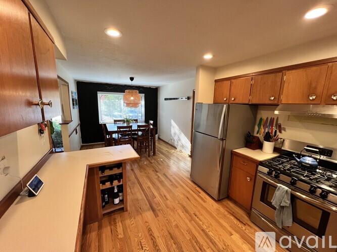 A kitchen with wooden cabinets and a stainless steel refrigerator.