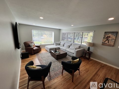 A living room with a black chair and a white couch.