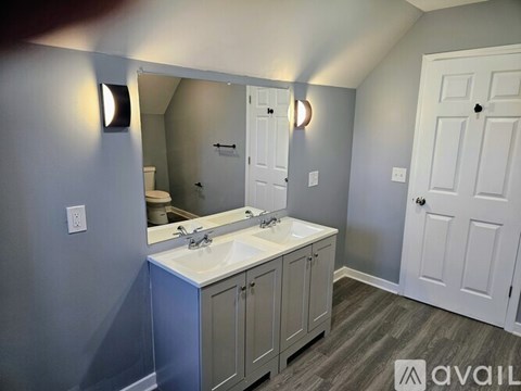 A bathroom with a sink, mirror, and cabinets.
