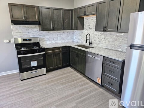 A kitchen with a stove, sink, and refrigerator.