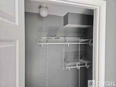 A white door with a shelving unit inside.