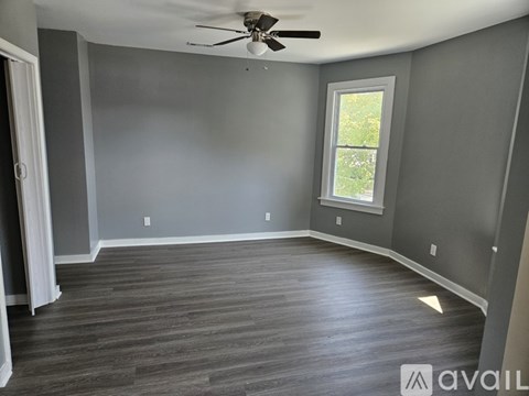 A room with a ceiling fan and a window.