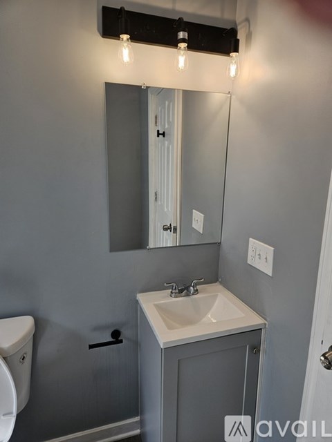 A bathroom with a sink, mirror, and toilet.