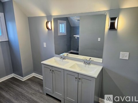 A bathroom with a double sink vanity and a large mirror.