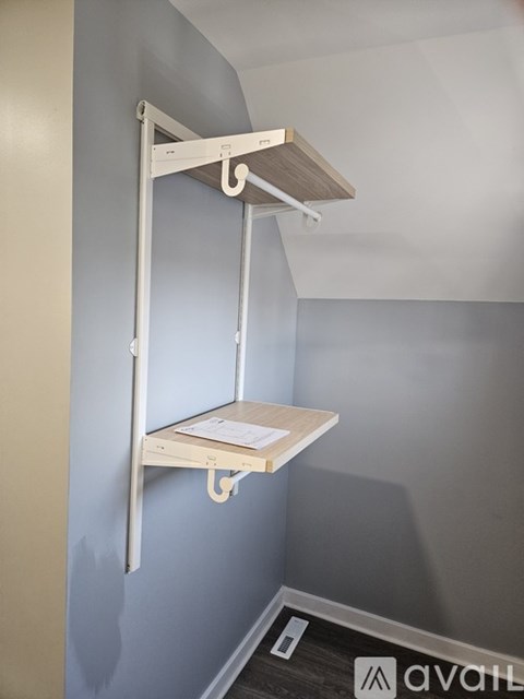A white shelf is mounted on a wall.