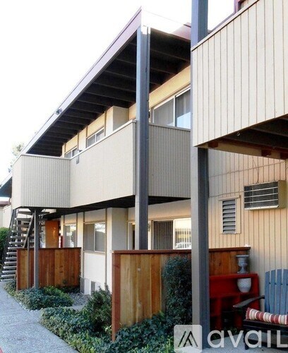 A modern building with a wooden fence and stairs leading to the entrance.