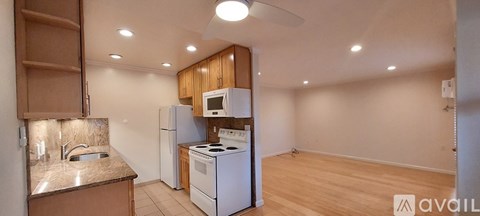 A kitchen with a white fridge and stove top oven.