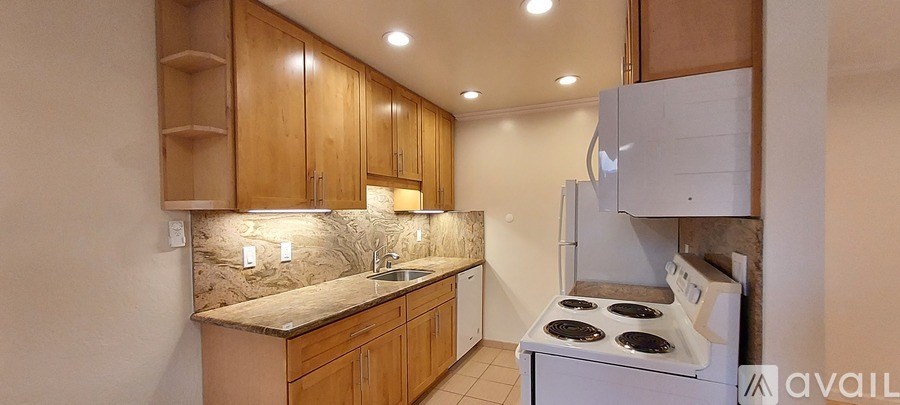A kitchen with wooden cabinets and a white stove top oven.