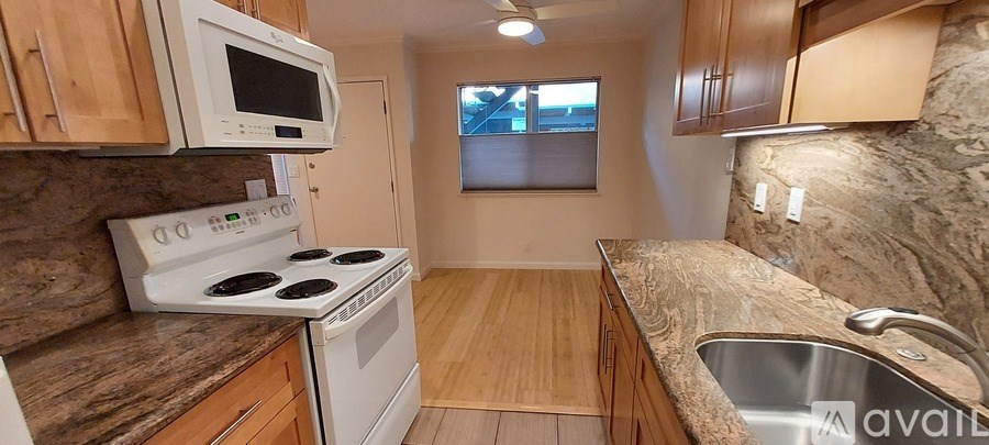A kitchen with a stove, microwave, and sink.