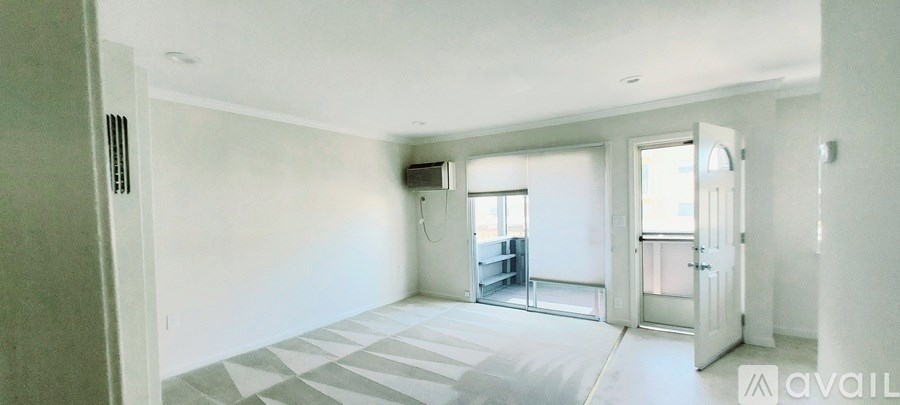 A spacious living room with a grey and white tiled floor and a large window.
