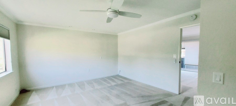 A room with a fan and a window.