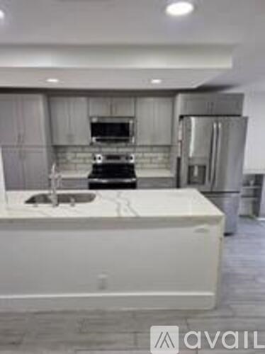A modern kitchen with a white island in the middle.