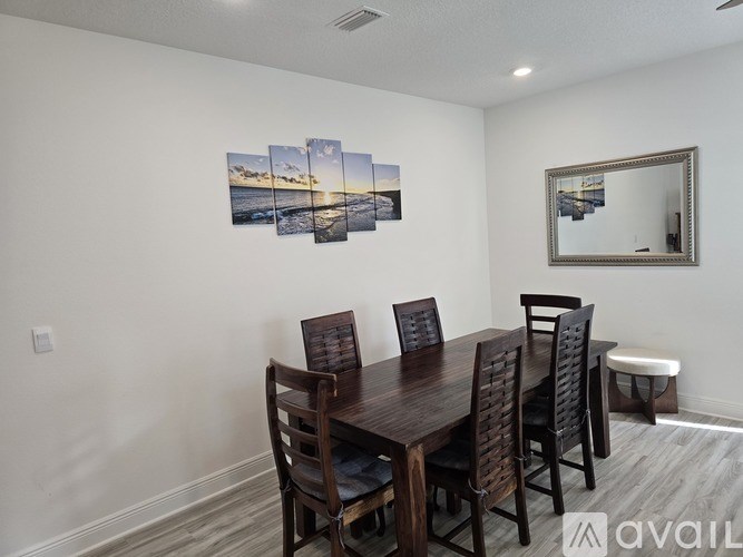 A dining room with a wooden table and chairs.